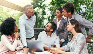 Grupo de seis pessoas discutindo e colaborando ao ar livre, envolvendo um gerente com equipe diversificada, em um ambiente profissional ao ar livre, com árvores verdes ao fundo e um laptop na mesa.